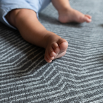 Little feet are cushioned the cushy play mat by Totter and Tumble with a modern monochrome design to complement nursery decor