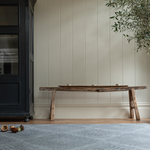 A one piece grey play rug unrolled in a modern family home that looks like a padded area rug