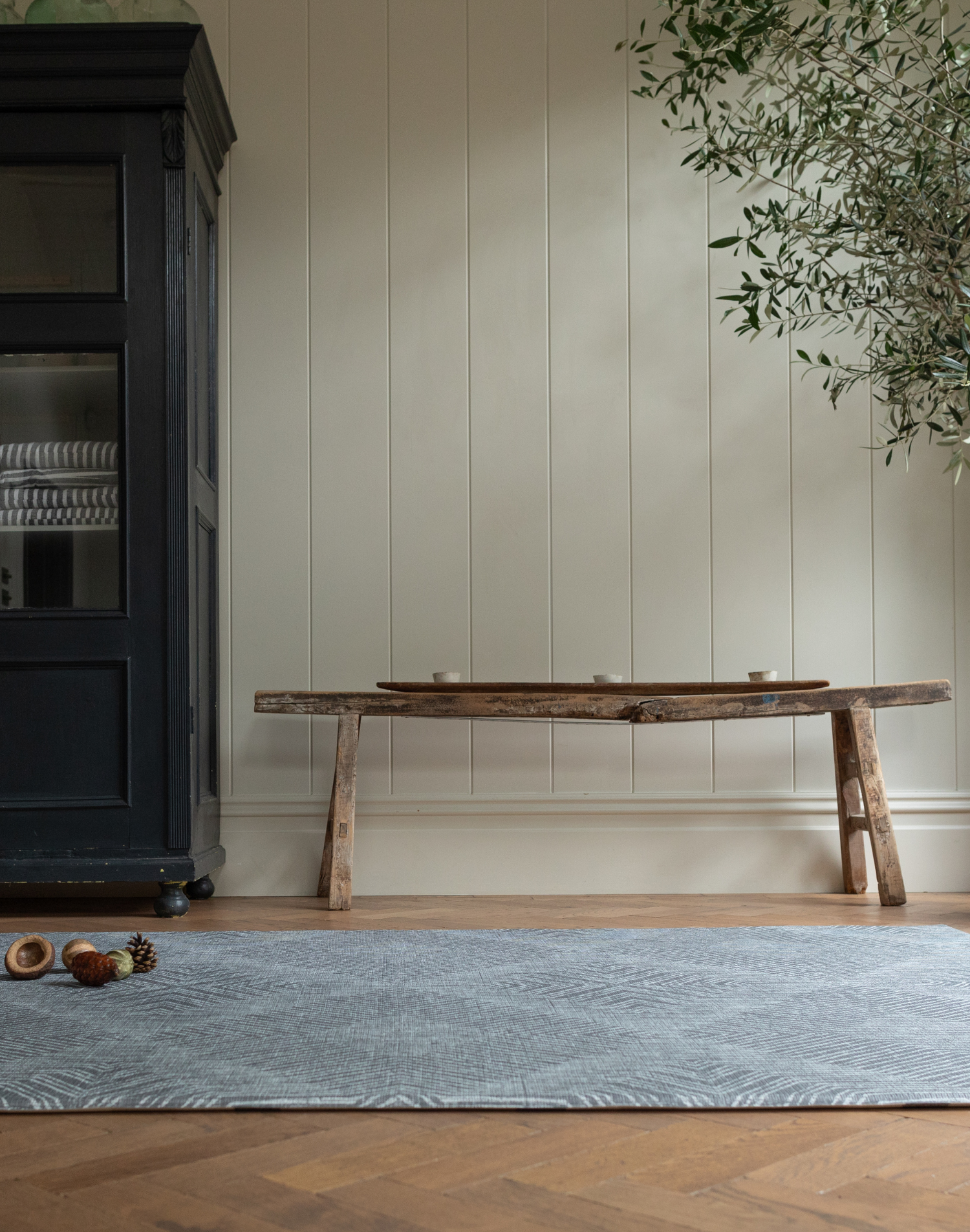 A one piece grey play rug unrolled in a modern family home that looks like a padded area rug