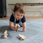 Little boy enjoys play time on the cushy play rug by Totter and Tumble with a monochrome grey and white rug design