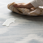 Cleaning milk spill on a Large round play mat by Totter and Tumble acts like a wipeable rug in the family home easy to clean spit up and spillages and looks stylish