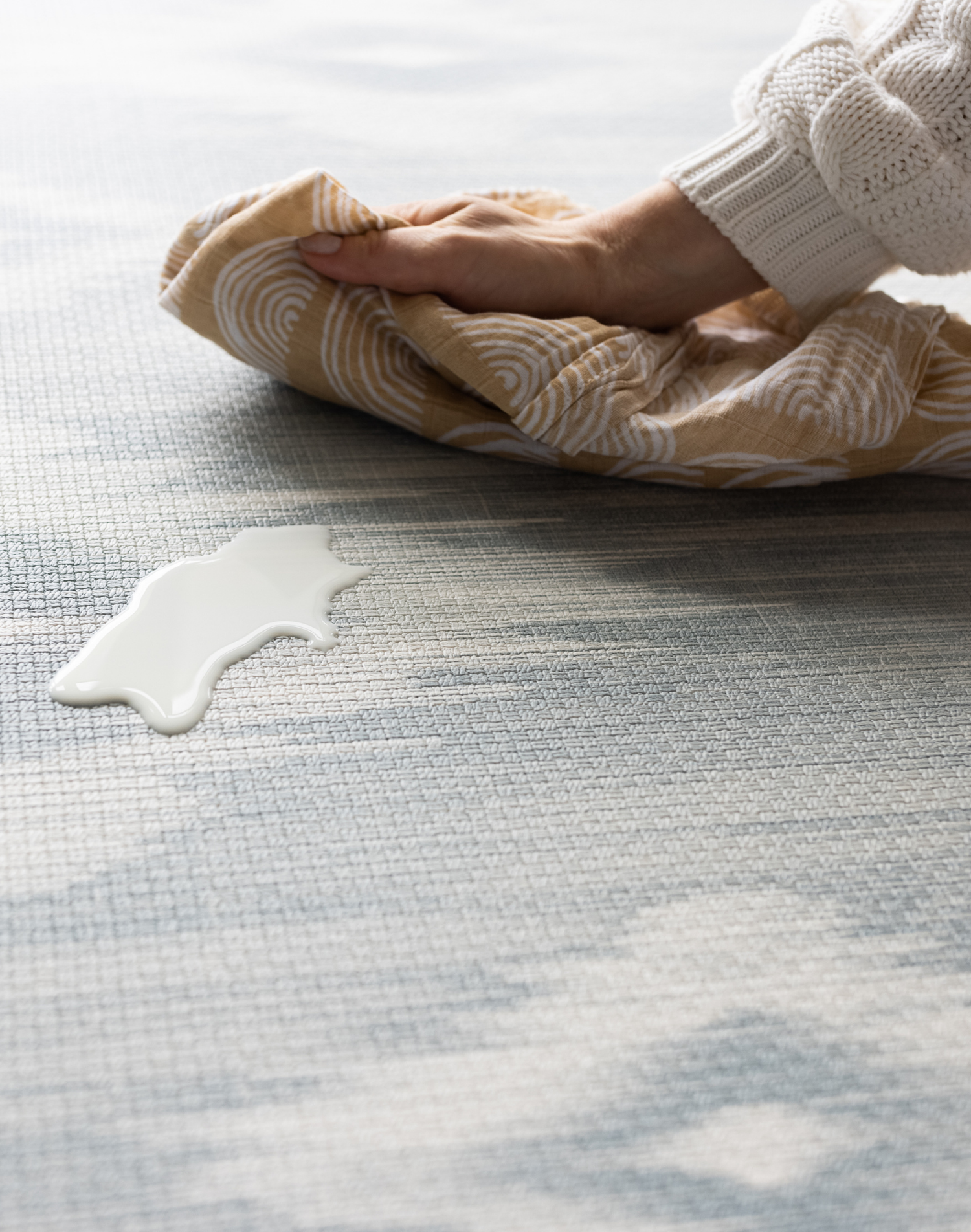 Cleaning milk spill on a Large round play mat by Totter and Tumble acts like a wipeable rug in the family home easy to clean spit up and spillages and looks stylish