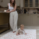 Mother and Baby relaxing in kitchen whilst using Totter and Tumble padded play mat