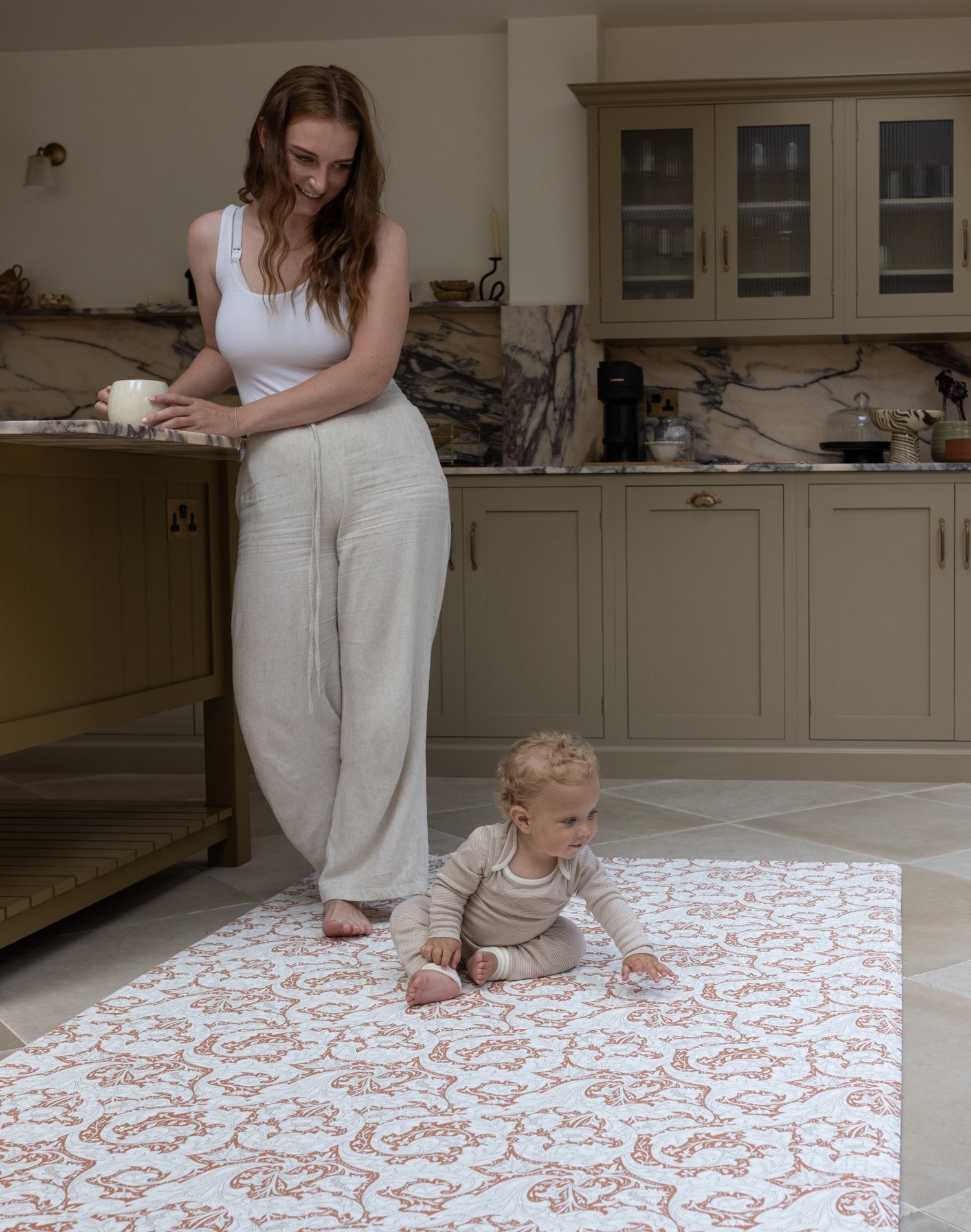 Mother and Baby relaxing in kitchen whilst using Totter and Tumble padded play mat