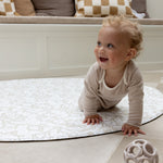 baby crawling on padded round play mat with Morris and Co designs