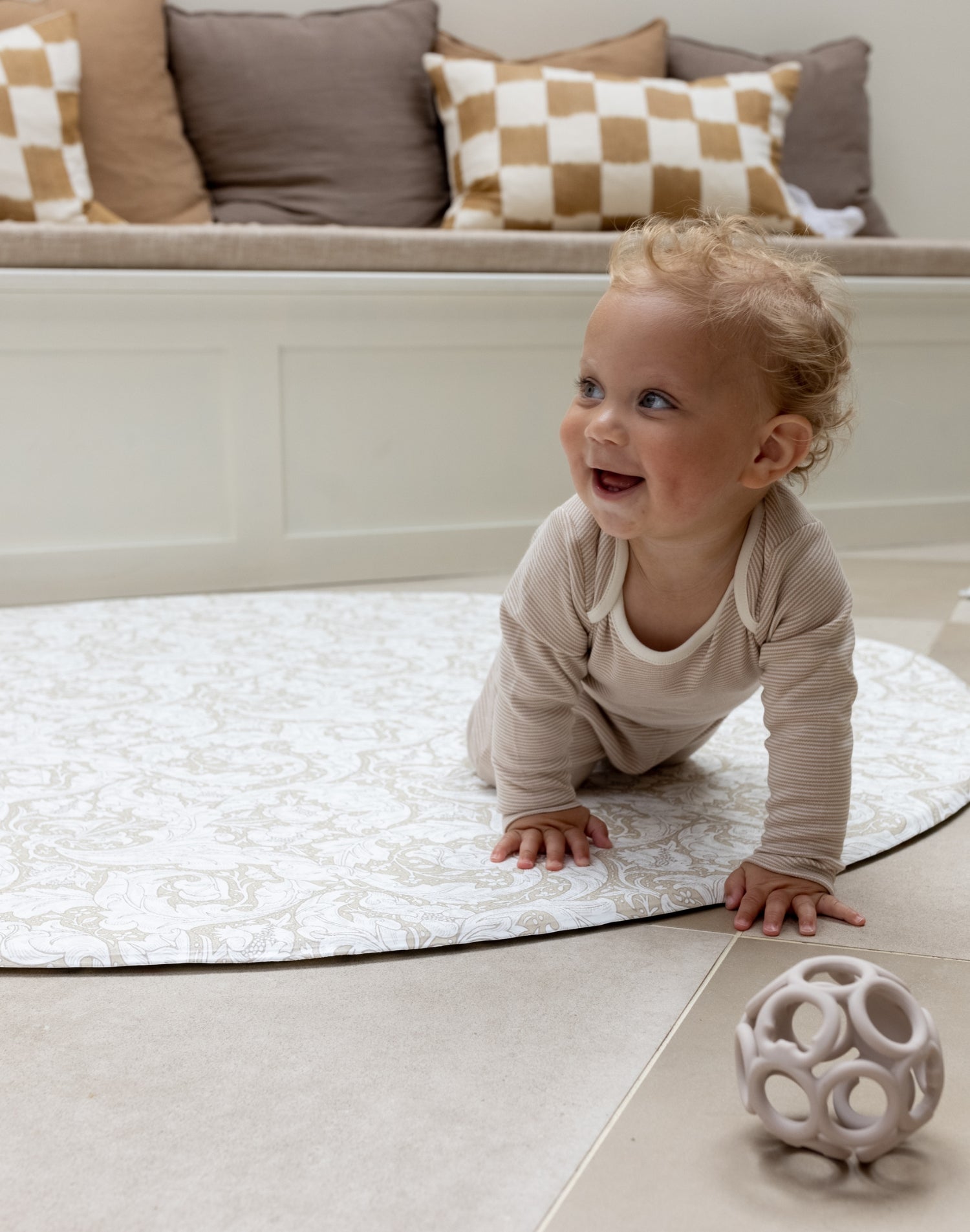 baby crawling on padded round play mat with Morris and Co designs