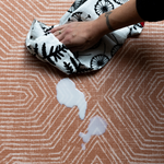 Wiping up spillage on anti slip playmat with contemporary terracotta design