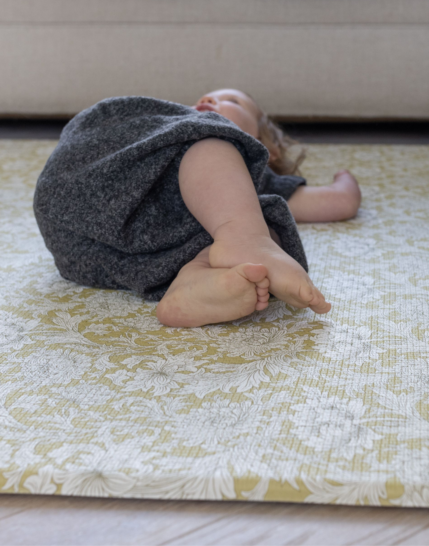 Toddler laying on textured floral memory foam Chrysanthemum play mat