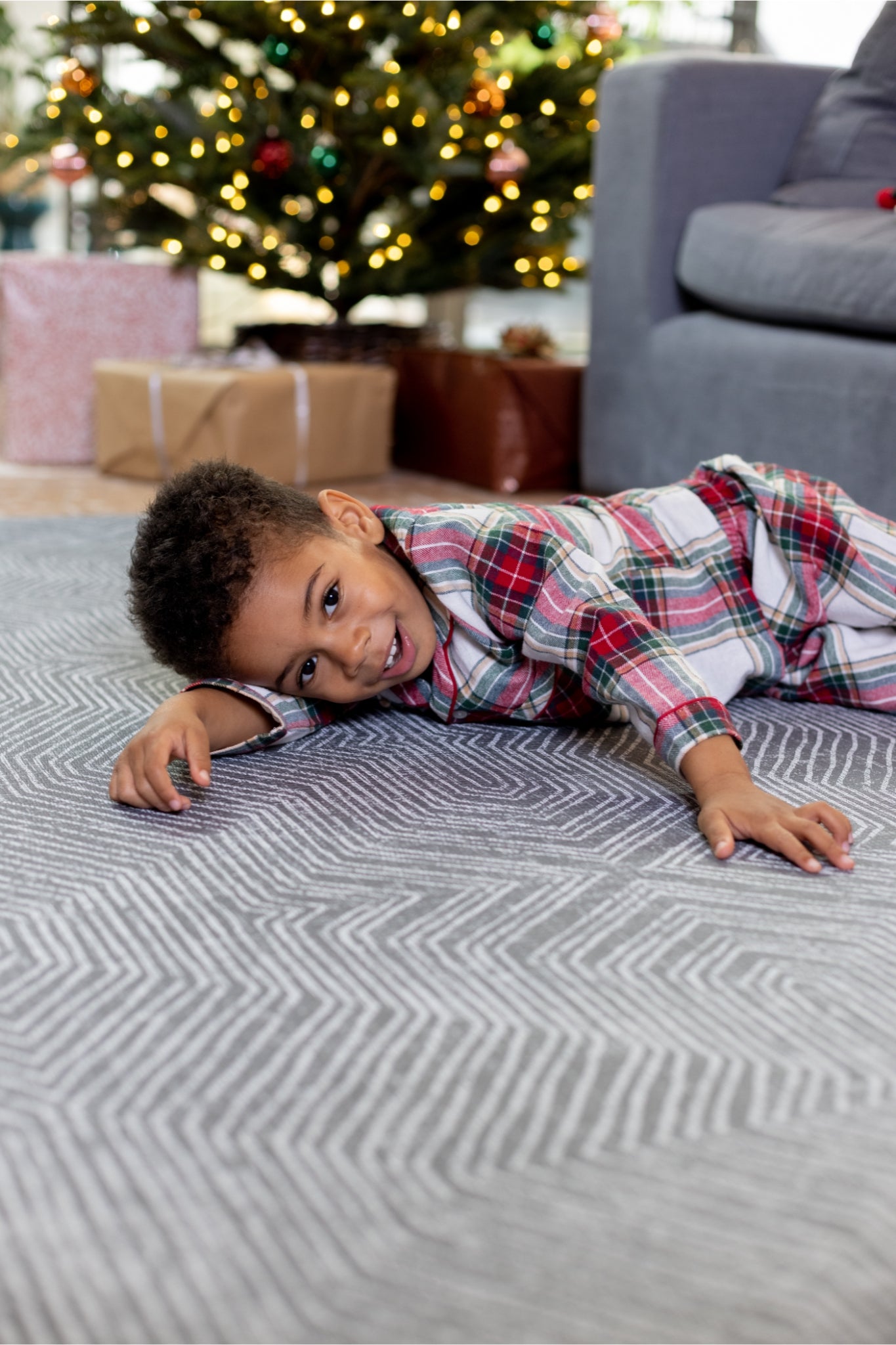 Baby playing at Christmas in a family room, sitting on a soft play mat