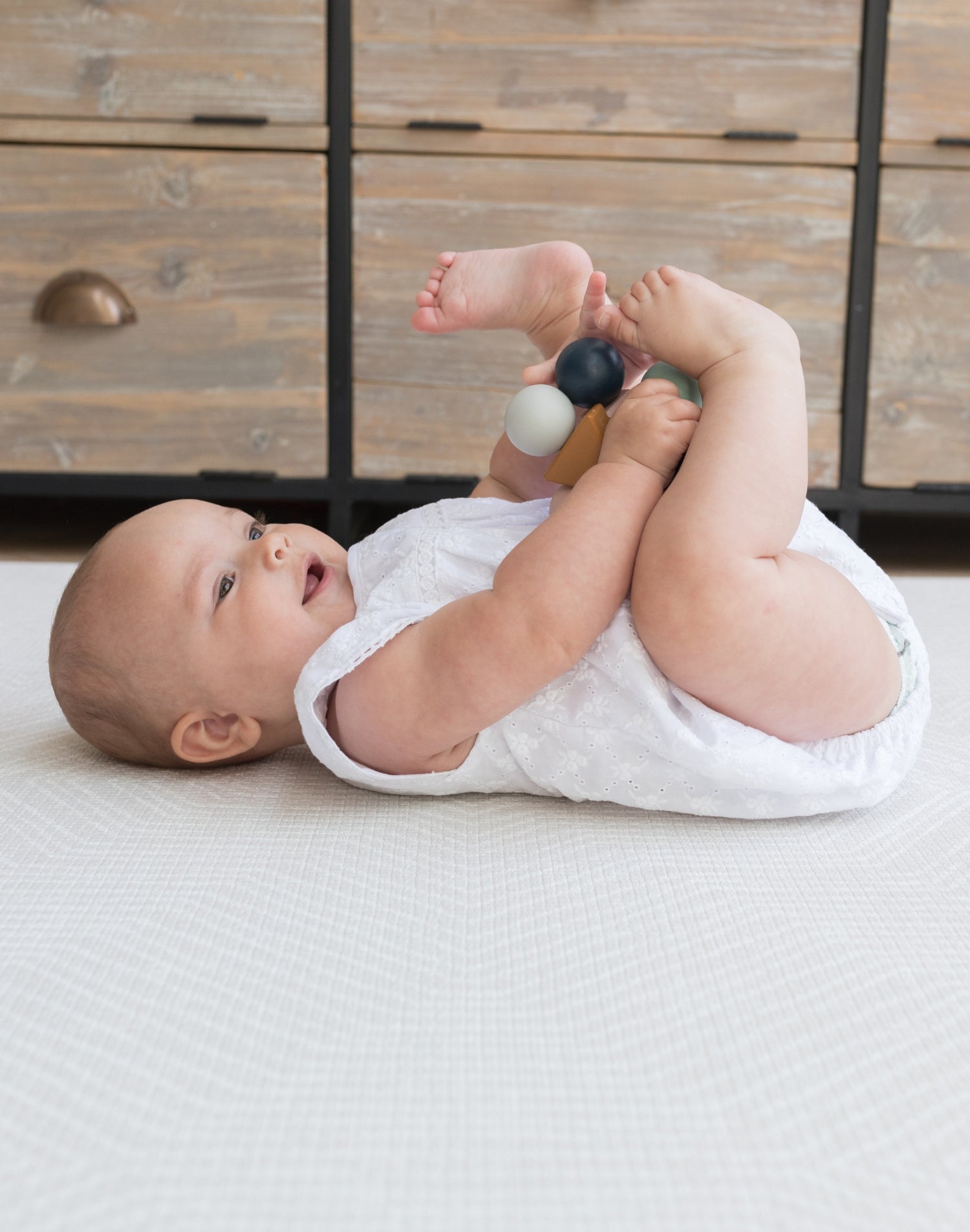 baby rolling on padded totter and tumble playmat