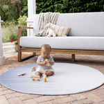 Baby playing on padded round play mat on the patio enjoying floor play in comfort keeping body cool on hot tiles 