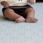 Little feet supported on scalloped foam mat that cushions to keep floor time comfortable