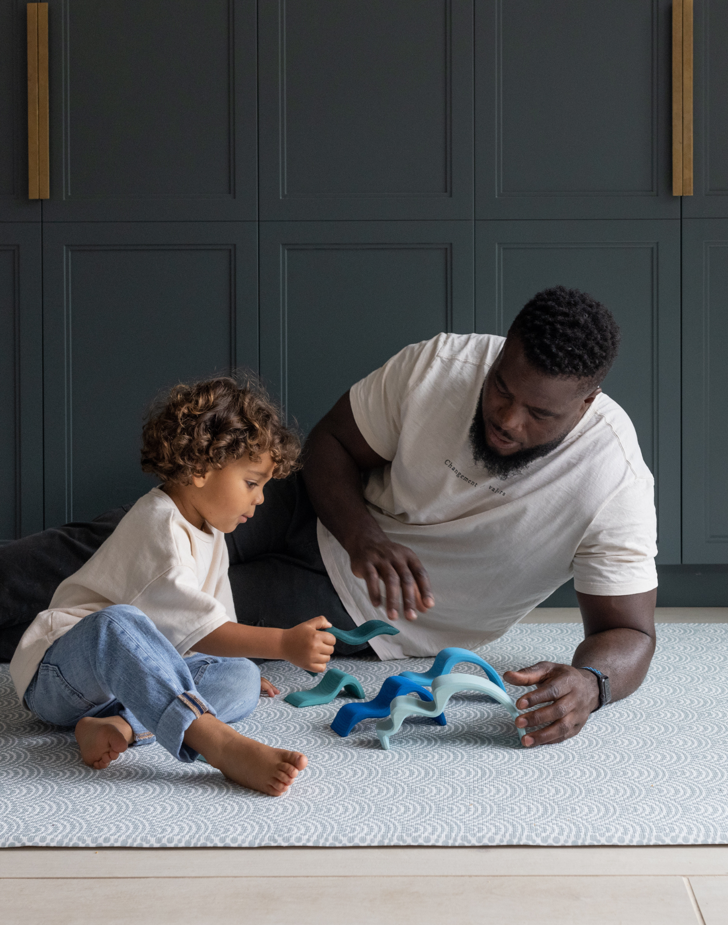 Adult and child enjoying floor play together kept comfortable by Totter and Tumble play mat made with cushiony memory foam for better support