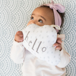 Little girl laying on cushy memory foam floor mat holding on to soft baby toy