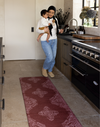 Mom and baby are busy in the kitchen with a argo foam kitchen mat in the red Merah motif to add style while also being highly functional in family homes