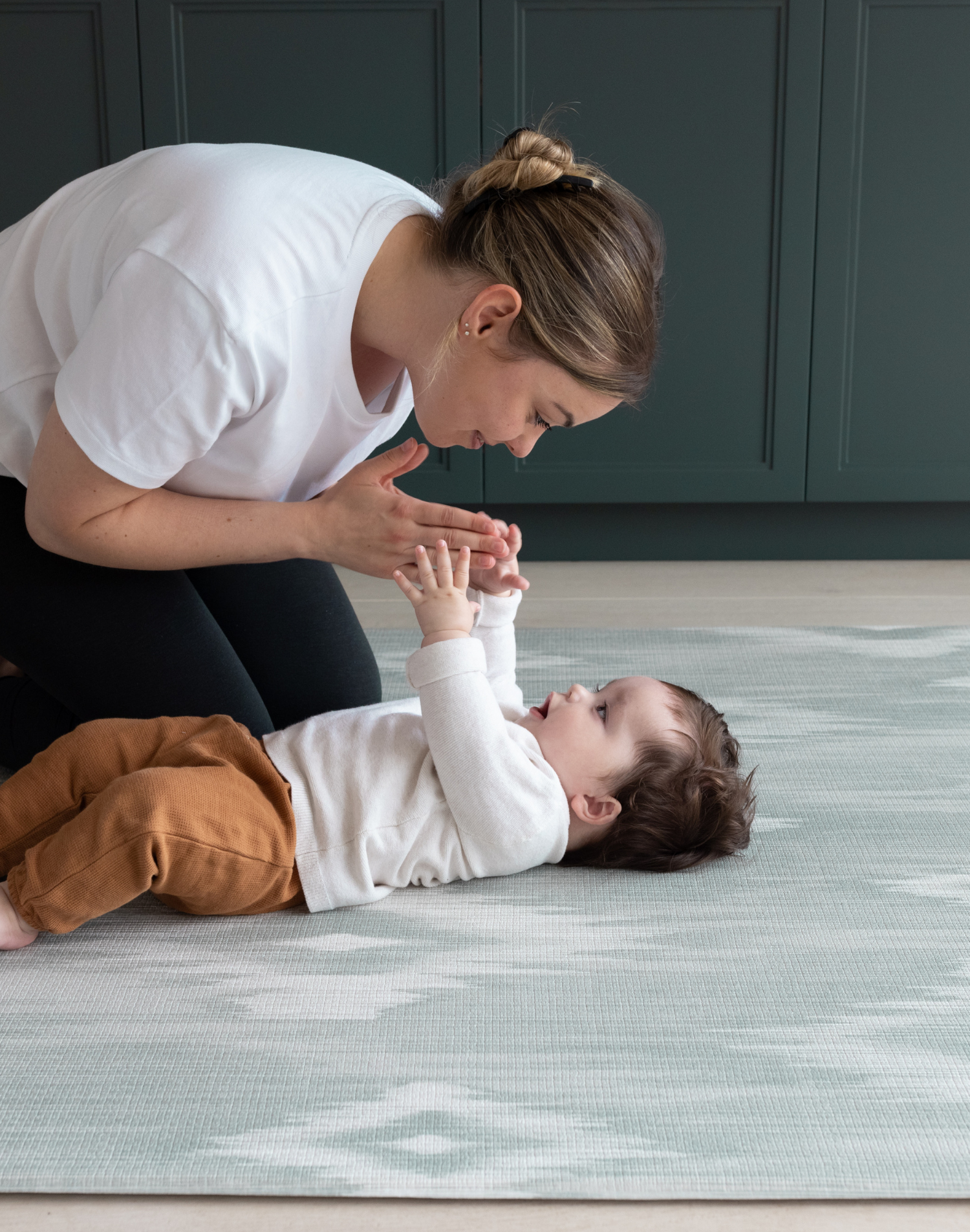 Mom and baby on Large round tumble mat by Totter and Tumble with modern ikat design to look like a rug in your home