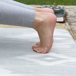 Feet are supported on moulding memory foam exercise mat by Totter & Tumble with textured surface for traction 