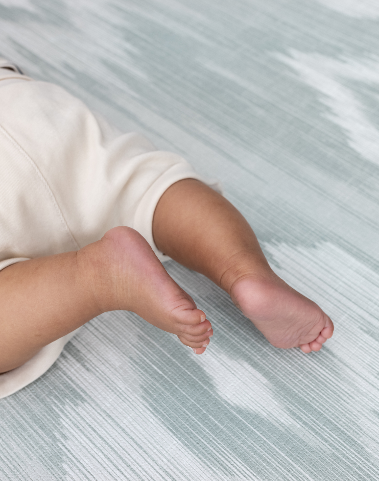 Close up of the Tumbling mats designed for safe floor play in a range of sizes and styles the Odissi is modern with a green and beige ikat design