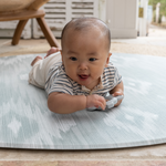 Baby enjoys tummy time on Large round tumble mat by Totter and Tumble with modern ikat design to look like a rug in your home