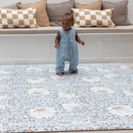 Baby standing on padded totter and tumble play mat from Morris and Co Collaboration