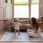 Baby standing on padded totter and tumble play mat from Morris and Co Collaboration