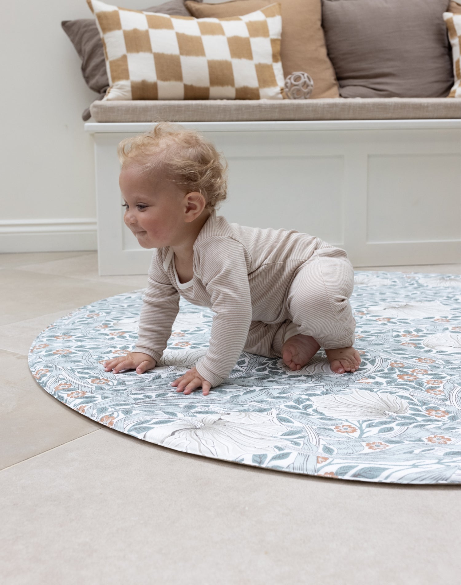 baby crawling on round pimpernel play mat