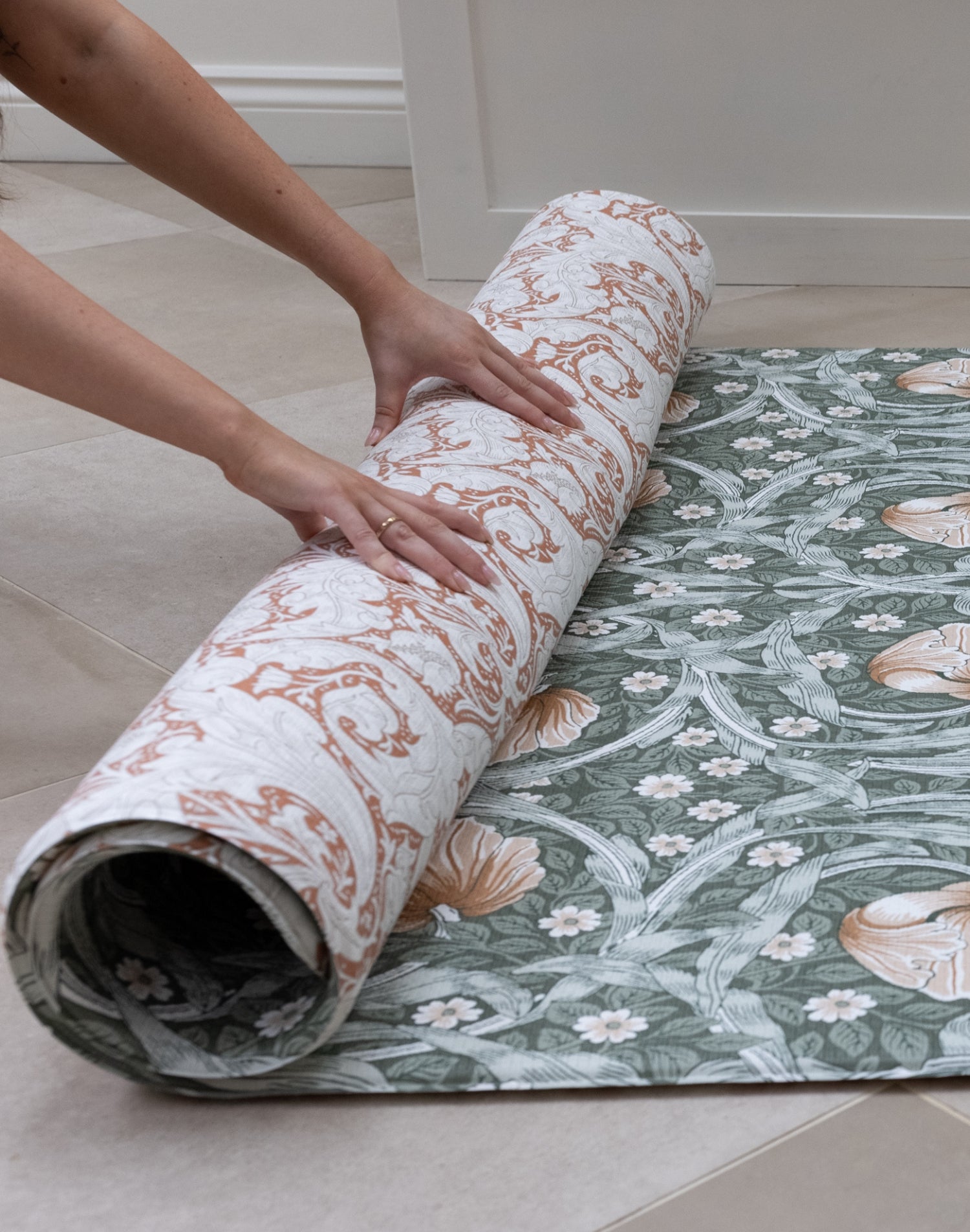 large soft play mat for kids being rolled out on the hard tiled floor