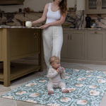 Mum and baby in family kitchen using padded play mat with Morris Pimpernel in green