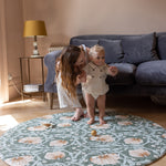 baby and parents playing on elegant round play mat in living room