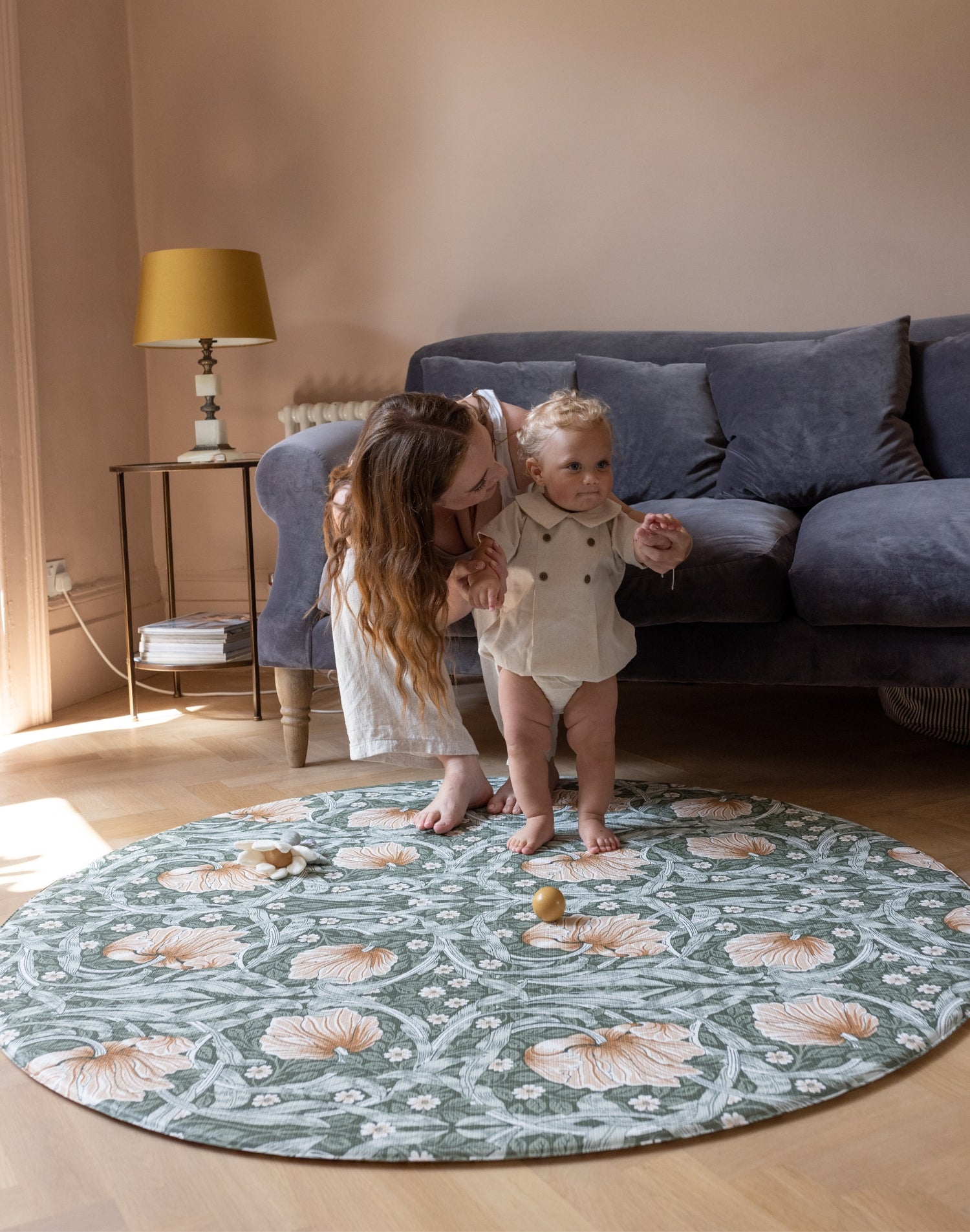 baby and parents playing on elegant round play mat in living room