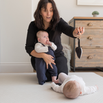 Lady and two babies enjoy time playing comfortably together on a neutral chevron play mat that sits subtly in the space it is placed