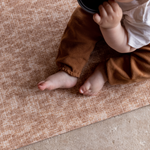 Baby sits unaided and comfortable on the subtle leopard print play mat with a jute texture for a subtle look thick memory foam supports and protects from any falls and tumbles on hard flooring