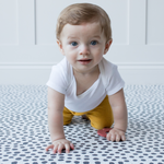 Baby is supported on a minimalist and sleek memory foam baby play mat that blends seamlessly with any decor