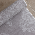 Close up of double sided gray play mat with intricate textile inspired design and a subtle animal skin motif on the reverse thick foam mat design provides comfort on hard tiled kitchen spaces  