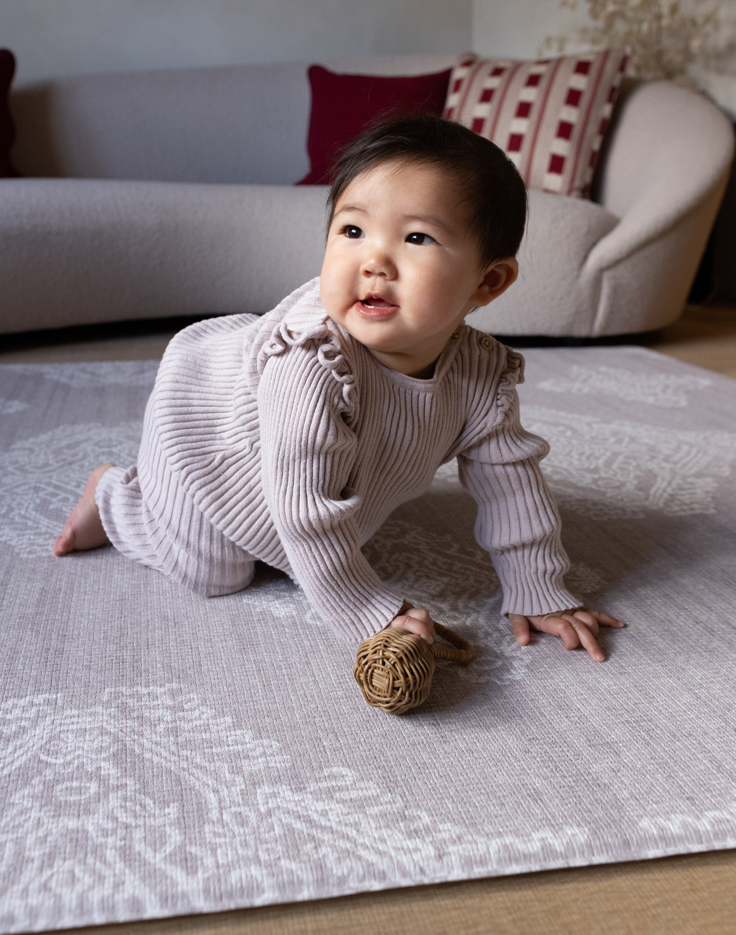 Baby crawls across the large gray play mat the sepi with supportive memory foam to keep babies and adults comfortable on the floor during play time and other activities