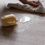 Hand wipes up milk spillage on sealed memory foam surface closed cell play mat design ensures cleaning is simple and doesn't harbor dust and dirt like textile rugs 