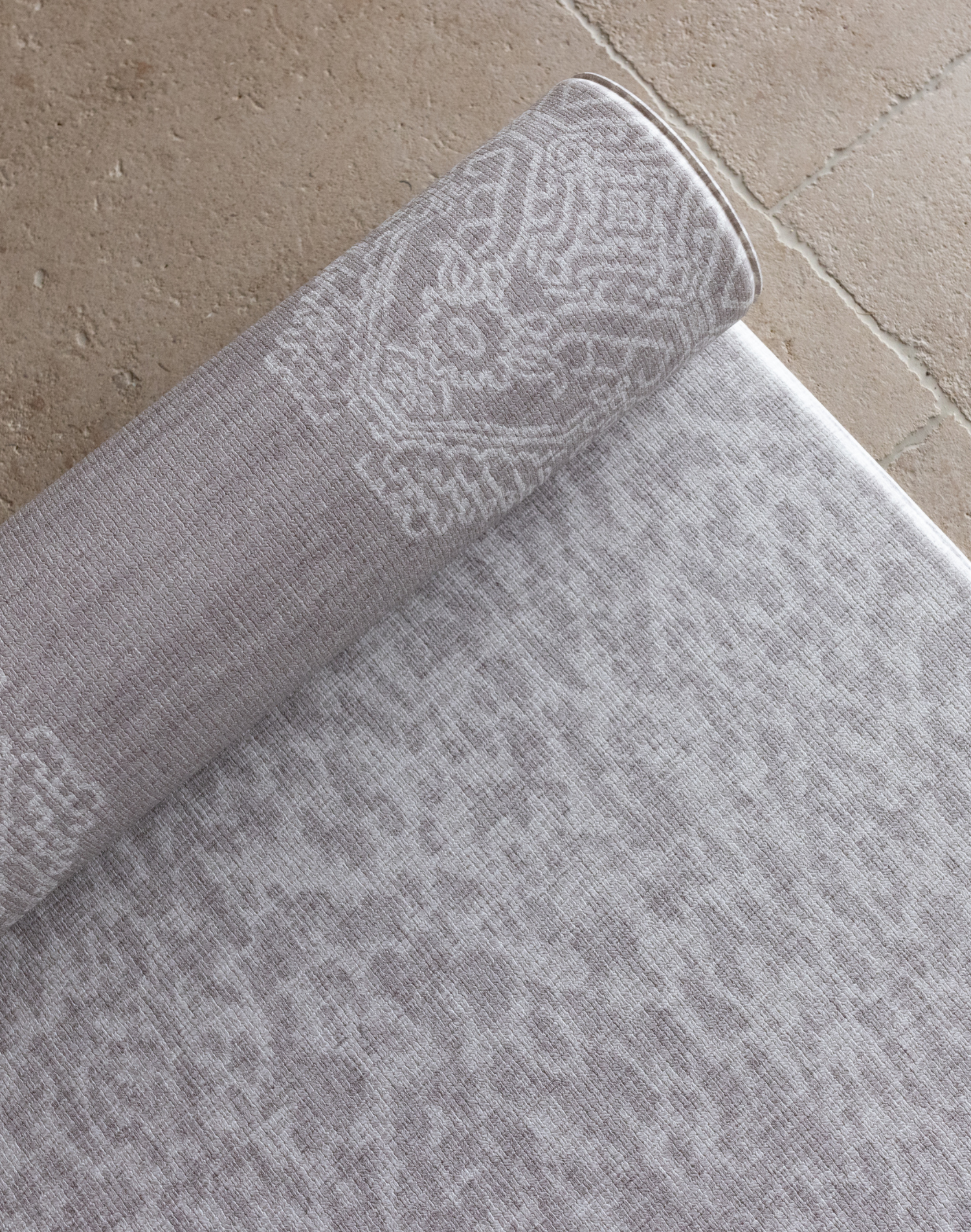 Close up of light gray play mat double sided designs to complement stylish interiors thick memory foam offers support on tiled flooring 