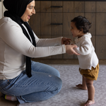 Mom and baby enjoy floor time on subtle animal print play mat the sunda by totter and tumble a modern gray play mat design for a stylish look in the home 