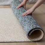 one-piece foam play mat rolled in double-sided morris & co designs The Standen and The Blackthorn totter + tumble foam mats that look like rugs