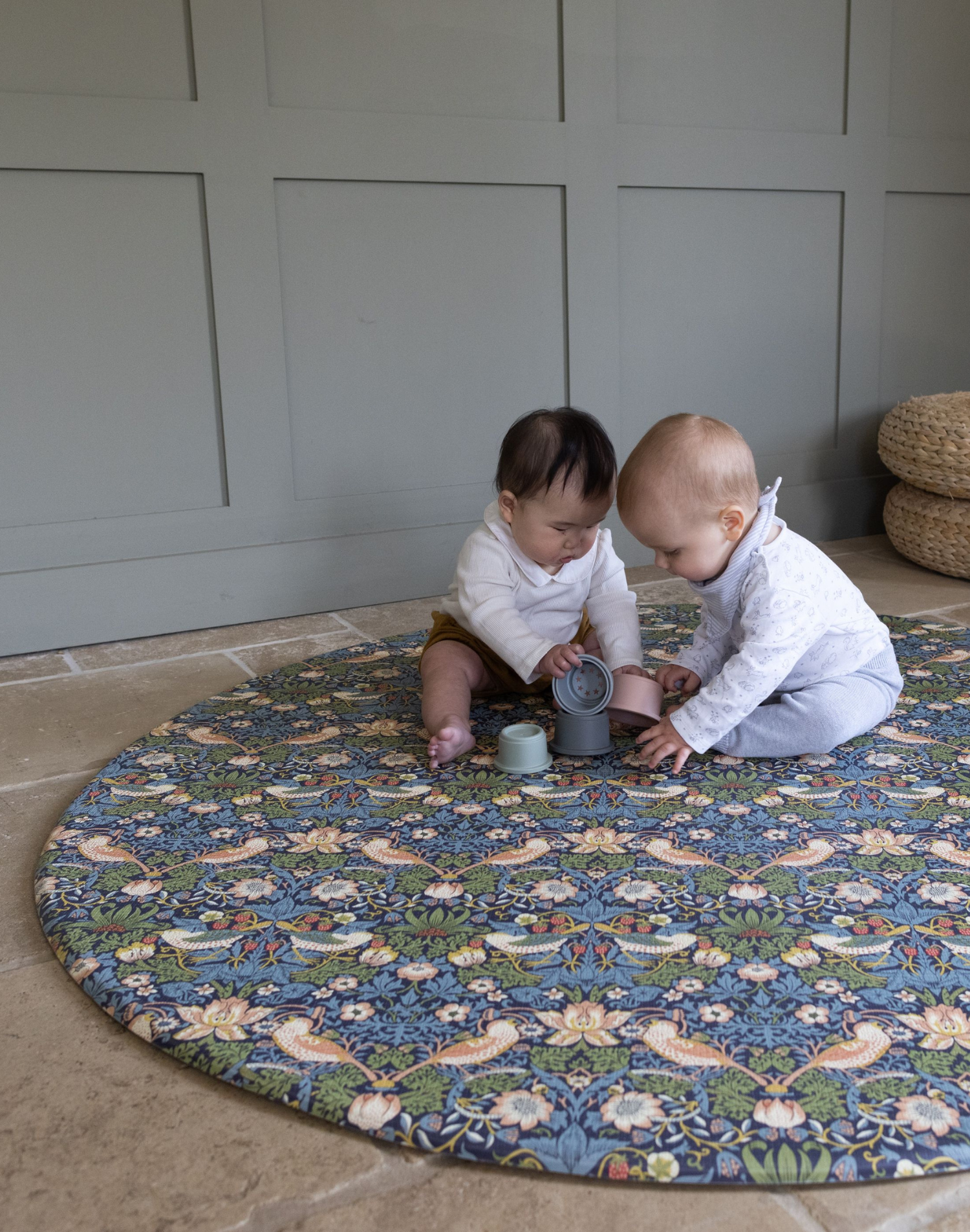 Adorable babies playing on round Totter and Tumble play mat with stacking cups enough space for fun play mats on the one-piece memory foam design