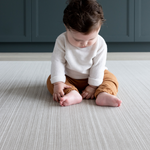 Child sitting on the Baby floor mat with stylish beige play mat design for family homes