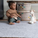 Child enjoys playtime on the non toxic play mat by totter and tumble with thick and safe design