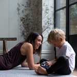 Mom and son relax together on foam kid play mats with a modern grey leopard design