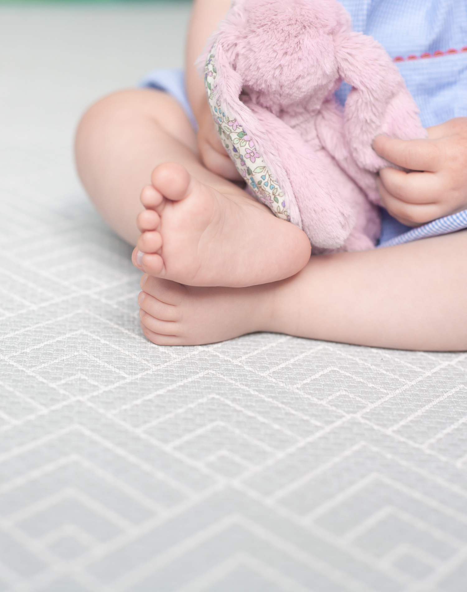 Baby sits unaided with the protection of a padded play mat