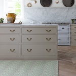 Beautiful family kitchen with Totter and Tumble play mat unrolled against kitchen island the ideal play space for children with a wipeable surface to ensure cleaning is simple